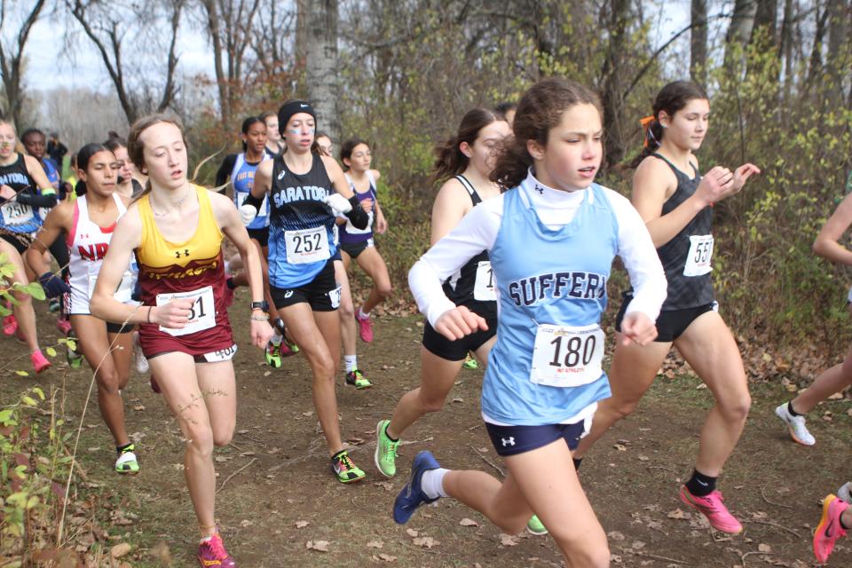 Suffern's Grace Delaney (180) and North Rockland's Gaby Castro and others run through a small wooded area during the girls Class A state cross-country championship Nov. 11, 2023 in Verona, New York.