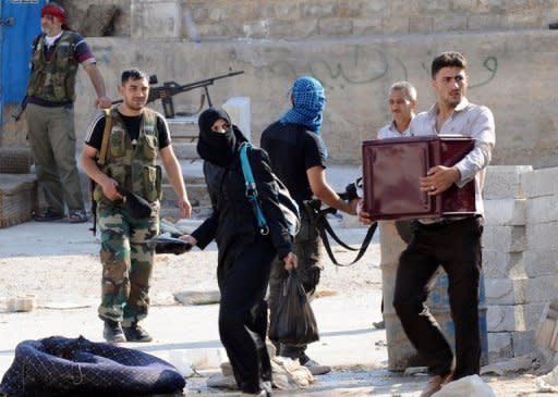 Syrian civilians carry their belongings as they flee clashes between the Syrian opposition and forces loyal to President Bashar al-Assad, in the center of Syria's restive northern city of Aleppo. The Syrian army and rebels on Wednesday sent reinforcements to Aleppo to join the intensifying battle for the country's second city, as UN chief Ban Ki-moon urged the world "to stop the slaughter."