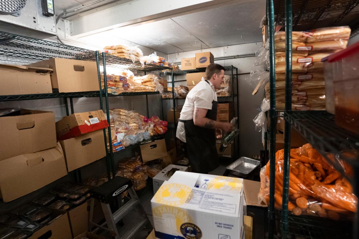 Chris McDermitt, chef at the Homeless Alliance, moves food stored inside a walk-in refrigerator at the nonprofit's day shelter in Oklahoma City.
