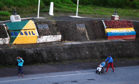FILE PHOTO: Venezuelans are pictured on the border with Venezuela, seen from the Brazilian city of Pacaraima, Roraima state, Brazil August 9, 2018. REUTERS/Nacho Doce/File photo