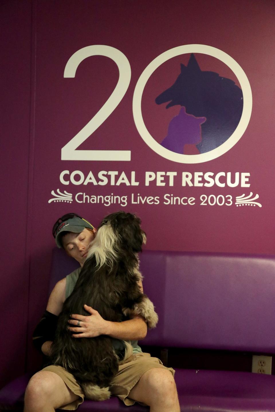 Coastal Pet Rescue volunteer Kallem Counterman holds Stormy, one of 21 dogs that have been rescued after being abandoned in the same area.