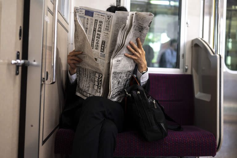 Un hombre lee el diario hoy durante un traslado en tren