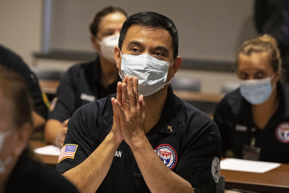 After his hands were blessed by a priest, Matthew Tran, a pharmacist, prays with nearly three dozen other healthcare workers from around the country who arrived to help supplement the staff at Our Lady of the Lake Regional Medical Center in Baton Rouge, L (Ted Jackson / AP)