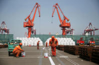 FILE PHOTO: Workers paint the ground at a port in Qingdao, Shandong province, China April 9, 2018. REUTERS/Stringer/File Photo