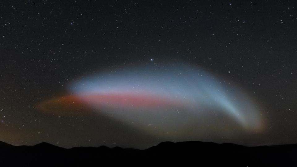 A red streak of light surrounidng by bright white light in the night sky