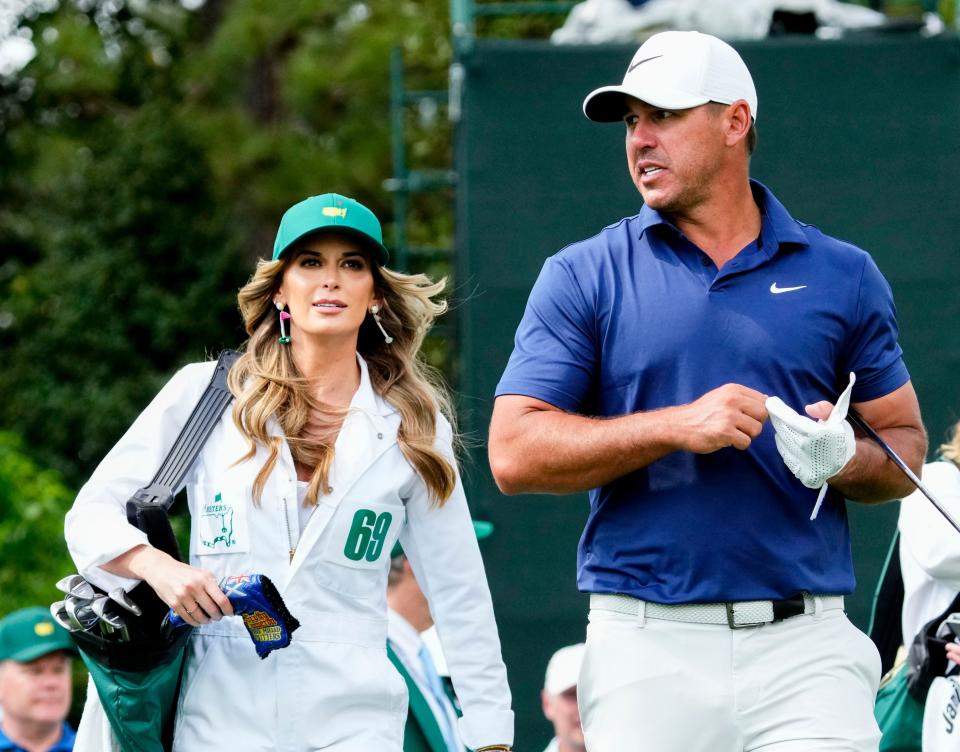 Jenna Simms caddies for her husband, Brooks Koepka, during the Par 3 Contest at The Masters golf tournament at the Augusta National Golf Club in Augusta, Ga., on April 5, 2023.