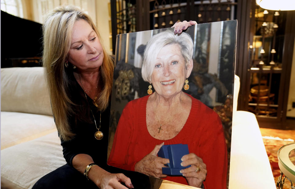 FILE - M.J. Jennings looks at a photo of her mother Leah Corken while sitting at her home in Dallas, Wednesday, Nov. 3, 2021. Corken was one of 22 women in the Dallas area who Billy Chemirmir was charged with killing. Officials say Chemirmir was killed by his cellmate Tuesday, Sept. 19, 2023, in a Texas prison. (AP Photo/LM Otero, File)