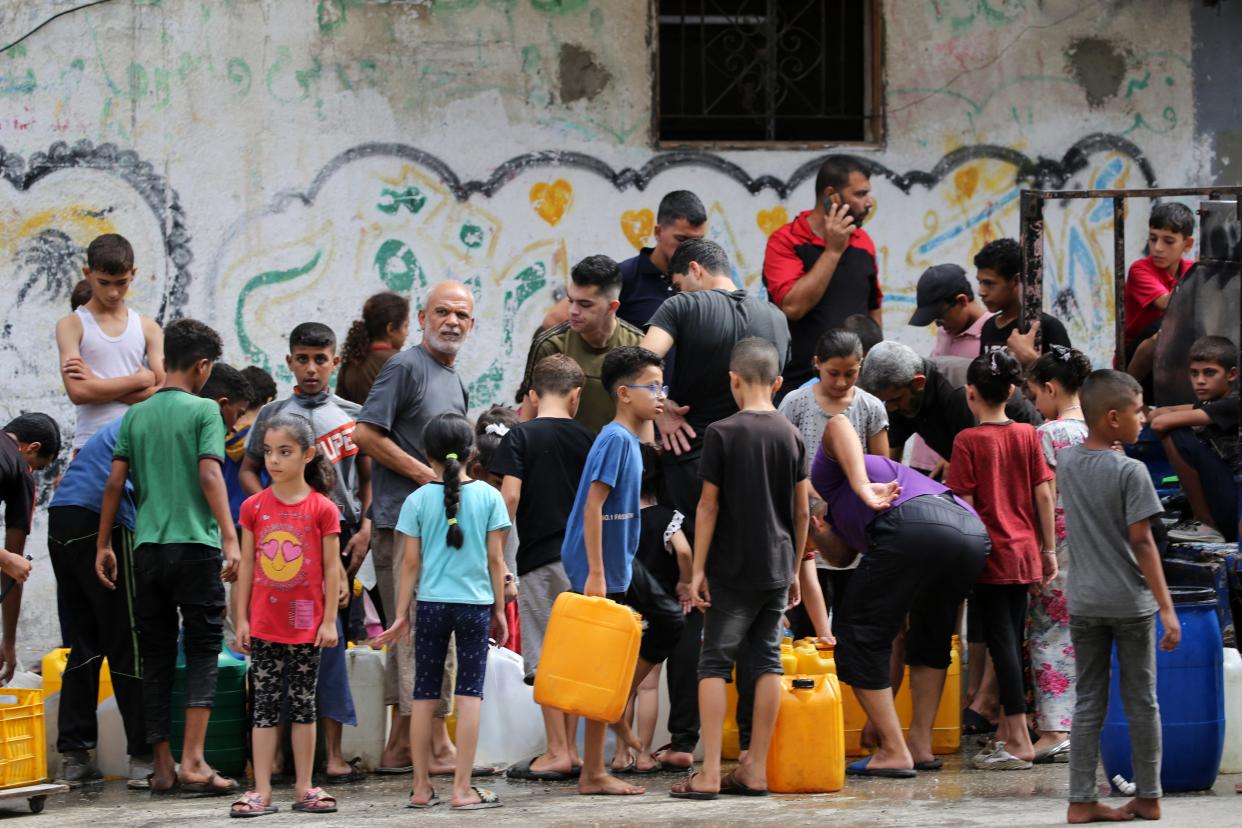 Palestinian children queue at a water distribution point in the Bureij refugee camp in central Gaza Strip (AFP via Getty Images)