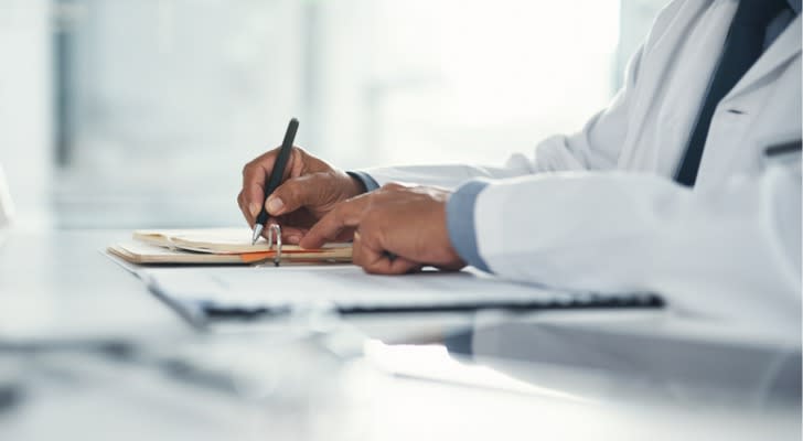 A doctor writes a prescription for a patient.