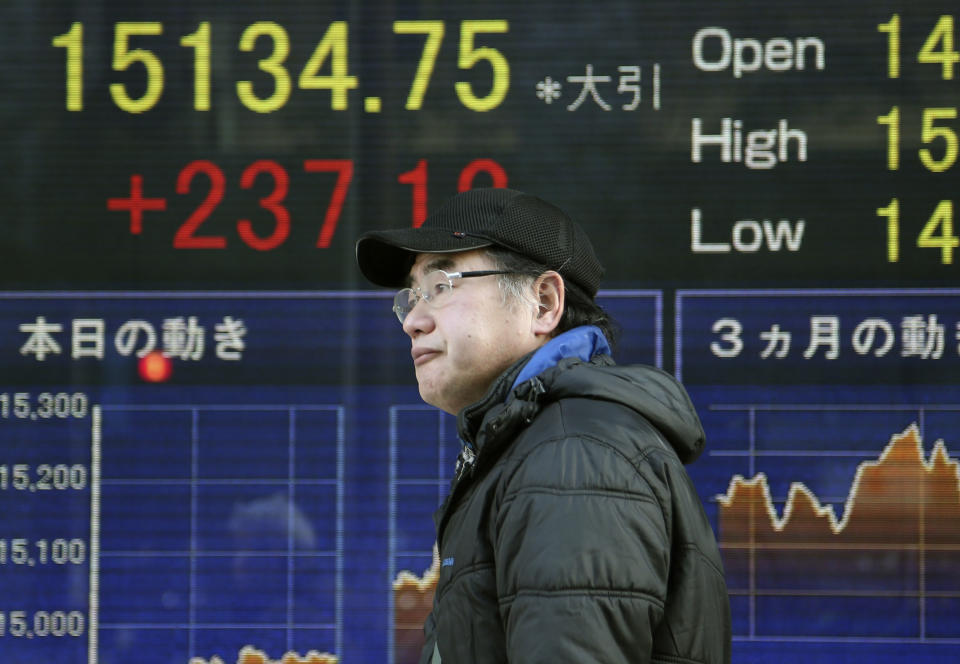 A man walks by an electronic stock board of a securities firm in Tokyo, Thursday, March 6, 2014. Japan's Nikkei 225 stock average was up 1.5 percent at 15,120.01 as the dollar headed back toward 103 yen after dropping in previous days on safe-haven buying of the Japanese currency. (AP Photo/Koji Sasahara)