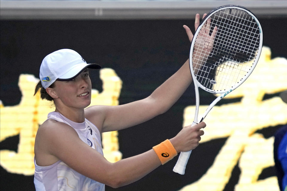 Iga Swiatek of Poland waves after defeating Cristina Bucsa of Spain during their third round match at the Australian Open tennis championship in Melbourne, Australia, Friday, Jan. 20, 2023. (AP Photo/Dita Alangkara)