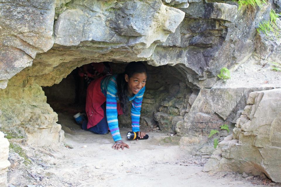 Synphanie Williams crawls through a cave at Cherney Maribel Caves County Park in Cooperstown on Aug. 6, 2015. Williams was on a tour of the park with her Girl Scout troop from Manitowoc.