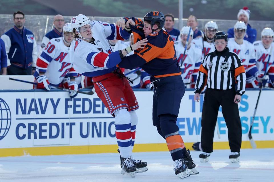 New York Rangers center Matt Rempe (73) and New York Islanders left wing Matt Martin (17) fight during the first period of a Stadium Series ice hockey game at MetLife Stadium.