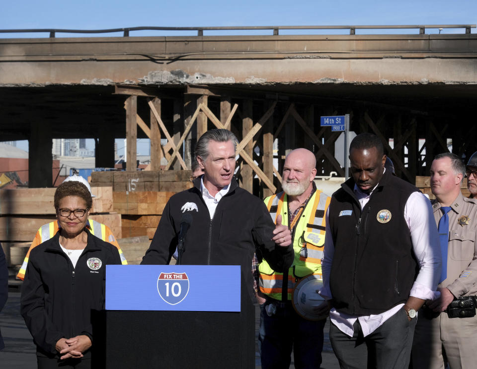 California Gov. Gavin Newsom, center, joined by Los Angeles Mayor Karen Bass, left, speaks during a news conference about repairs for a stretch of Interstate 10, Tuesday morning Nov. 14, 2023, in Los Angeles. It will take at least three weeks to repair the Los Angeles freeway damaged in an arson fire, the Newsom said Tuesday, leaving the city already accustomed to soul-crushing traffic without part of a vital artery that serves hundreds of thousands of people daily. (Dean Musgrove/The Orange County Register via AP)