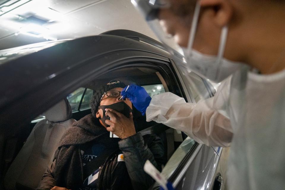Lisa Bryson, 47, of Detroit, gets a COVID-19 test adminsitered by Alexandra Sims, LPN, during the drive through clinic held by the city of Detroit on Tuesday, Jan. 6, 2022, at the Huntington Place Atwood garage (former TCF Center).