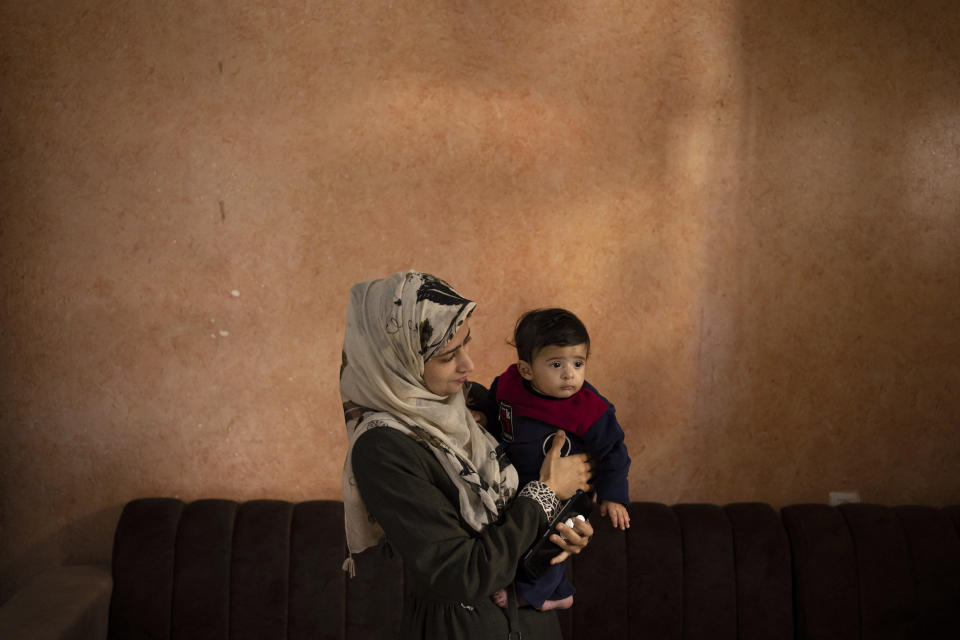 Amal Al-Taweel posea para una foto con su bebé Ali en la casa familiar en Nuseirat, en el centro de la Franja de Gaza, el viernes 5 de abril de 2024. Ali nació el 7 de octubre, el día que estalló la guerra entre Israel y Hamás. Las madres que dieron a luz ese día temen que sus bebés de seis meses no han conocido más que una guerra brutal caracterizada por la falta de alimento para bebés, condiciones antihigiénicas en los refugios y el impacto de los ataques aéreos. (AP Foto/Fatima Shbair)