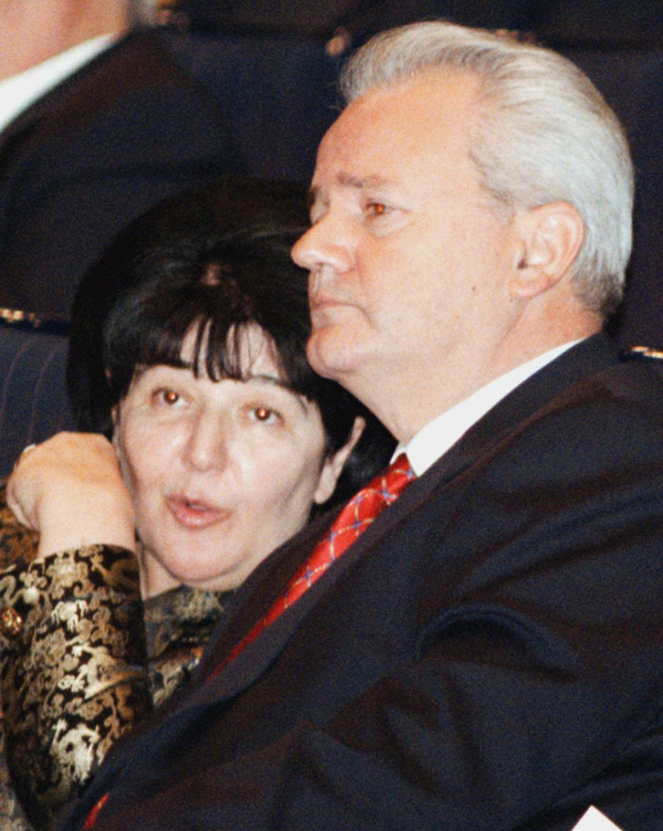 FILE - In this Tuesday, Dec. 1, 1998 file photo, Yugoslav President Slobodan Milosevic listens his wife Mirjana Markovic, the leader of YUL-Yugoslav United Leftists, as she talks to him during a solemn ceremony marking 80th anniversary of the forming of first Yugoslav state, in Belgrade. Serbia’s state television said that Mirjana Markovic, the widow of former strongman Slobodan Milosevic who was considered a power behind the scene behind his autocratic rule, has died in Russia on Saturday. She was 76, it was reported on Sunday, April 14, 2019. (AP Photo/Darko Vojinovic, file)