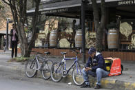 Venezuelan bicycle courier Luis Tarre, 60, reviews his cell phone as he waits for a Rappi delivery in Bogota, Colombia, Wednesday, July 17, 2019. In Colombia, which has recently taken in more than 1.3 million Venezuelans fleeing economic hardship, thousands of immigrants like Tarre are working on the Rappi platform, mostly delivering small packages to customers who can log into the app to order anything from Chinese takeaway to a box of diapers from the supermarket. (AP Photo/Fernando Vergara)
