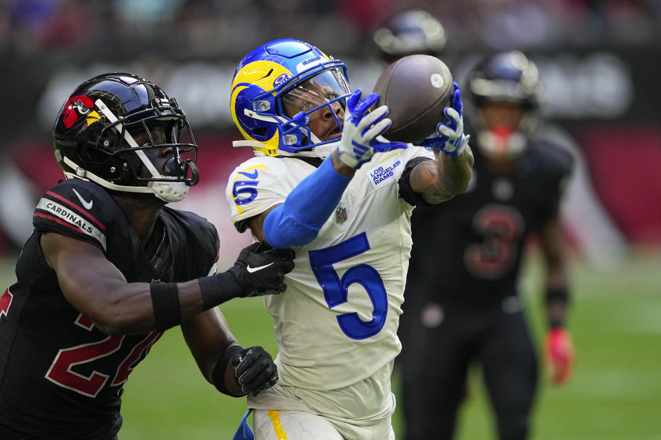 Los Angeles Rams wide receiver Tutu Atwell (5) hauls in a pass as Arizona Cardinals cornerback Starling Thomas V defends during the first half of an NFL football game, Sunday, Nov. 26, 2023, in Glendale, Ariz. (AP Photo/Matt York)