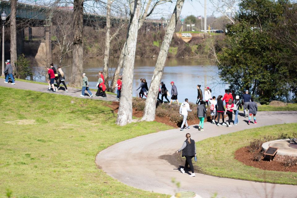 People walk along the Tuscaloosa Riverwalk in this  March 7, 2020, photo. On Saturday, the Phoenix House will host the &quot;Walk to End Addiction&quot; at the Riverwalk.  (Photo / Keely Brewer)