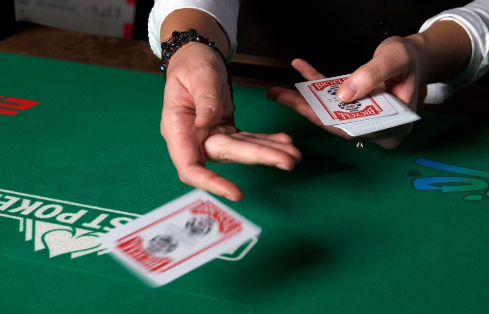 A dealer tosses out a card during the 2009 World Series of Poker at the Rio hotel-casino in Las Vegas.