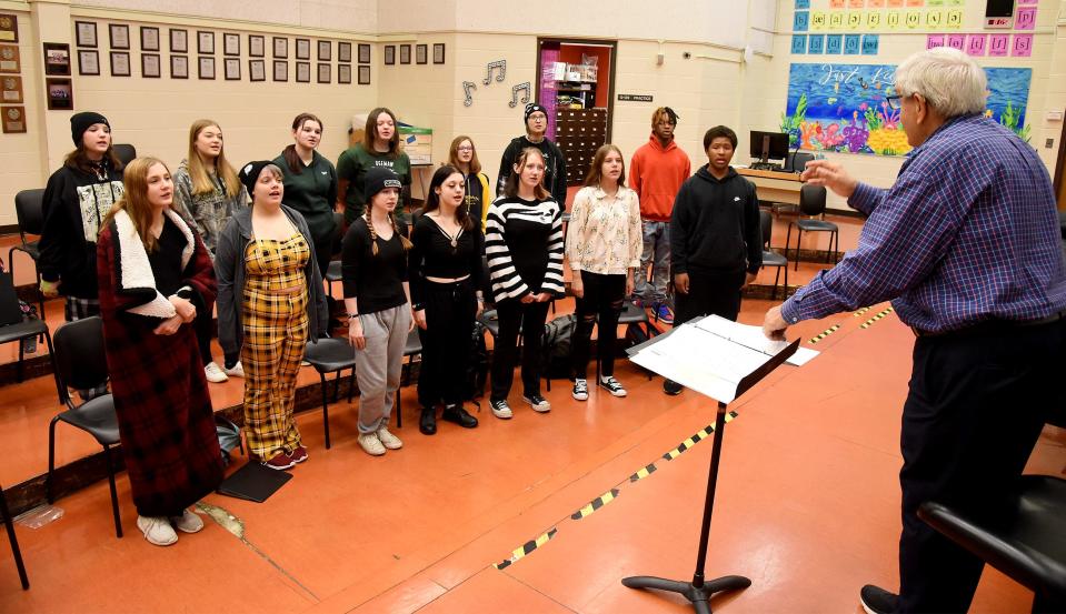 Monroe High School Concert Choir members rehearse the song "Alexander's Ragtime Band" on Wednesday with John Tyner, temporary director, while Bob Duris accompanies on piano. The full Concert Choir and Generations of Sound ensembles will perform tonight. The concert will include a tribute to choir director Cate Windelborn, who recently died.