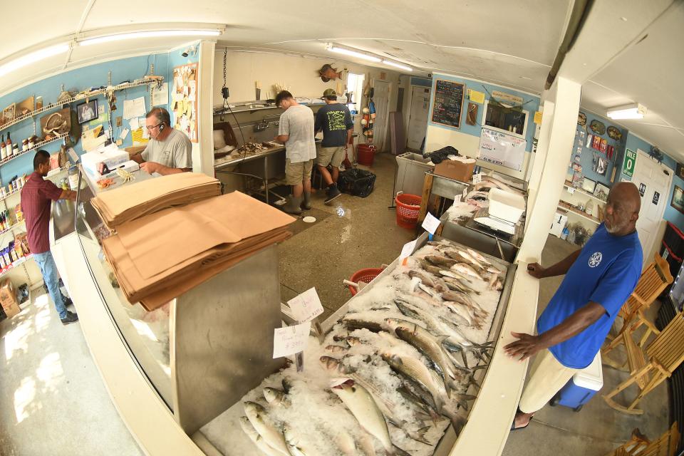 Owner Phil Guyer checks customers out at the register inside Coastal Seafood & Propane at 301 Village Rd NE in Leland, N.C. KEN BLEVINS/STARNEWS