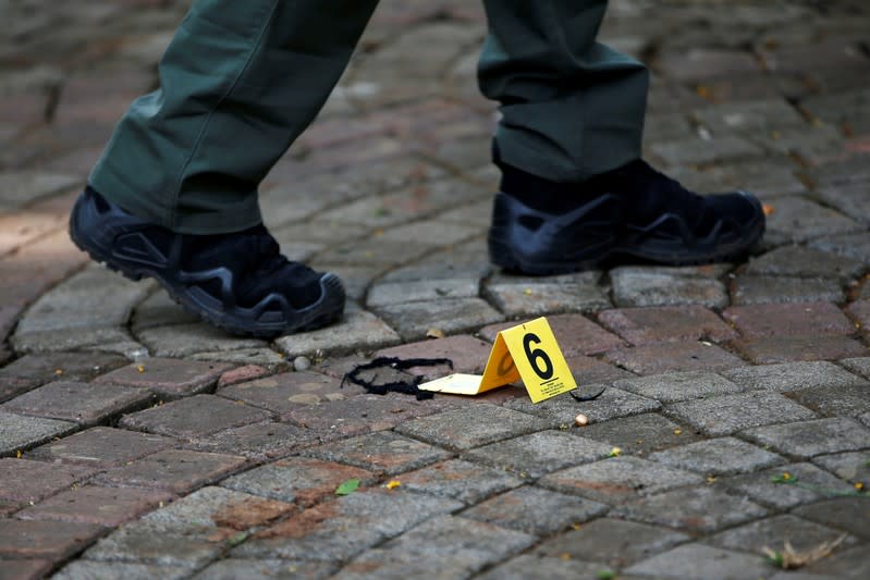 An Indonesian forensic policeman walks past an evidence marker as he investigates a blast at National Monument (Monas) complex in Jakarta