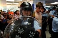 A protester is detained by the police officers at Amoy Plaza shopping mall in Kowloon Bay, Hong Kong