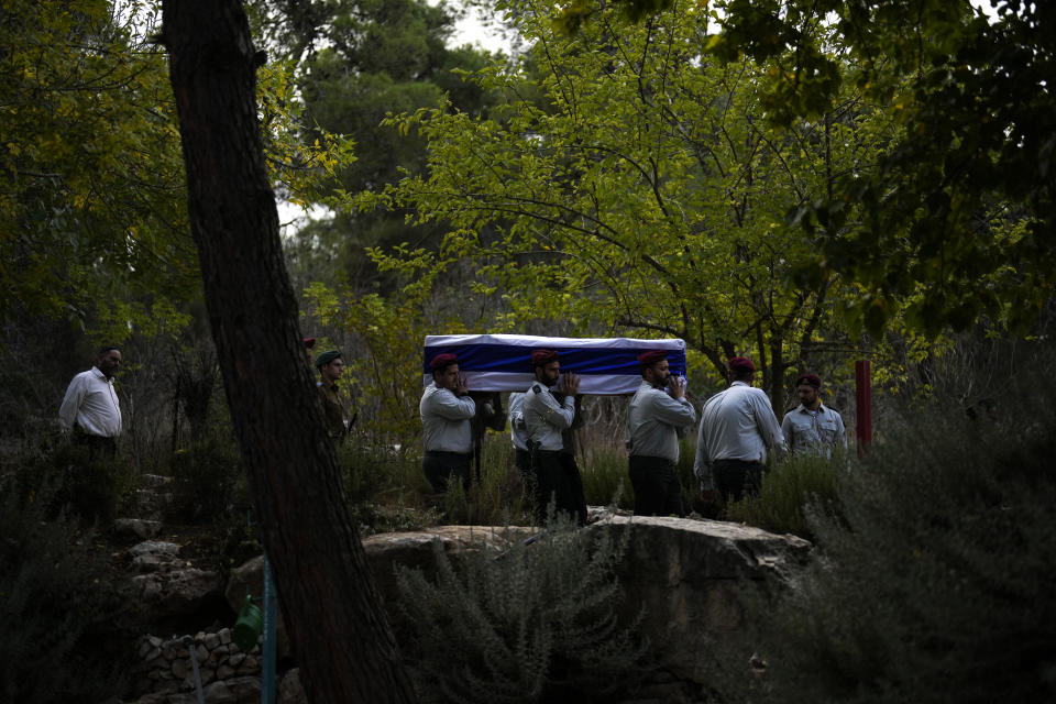 Israeli soldiers carry the flag-covered coffin of Maj. Tal Cohen during his funeral at the Givat Shaul cemetery in Jerusalem on Tuesday, Oct. 10, 2023. The latest Israel-Hamas war reverberated around the world Tuesday, as foreign governments tried to determine how many of their citizens were dead, missing or in need of medical help or flights home. (AP Photo/Francisco Seco)