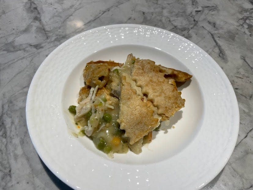 Slice of Kirkland Signature chicken pot pie with chicken, peas, and carrots oozing out