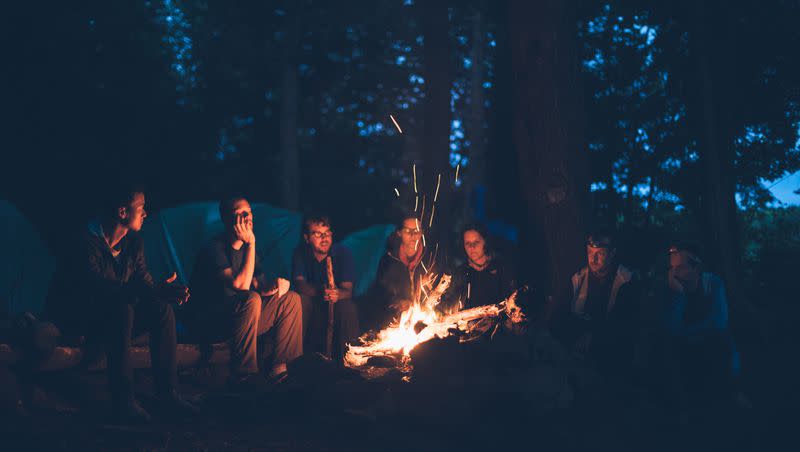 A group of friends sit around a campfire in Algonquin Park in Canada.