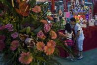 Children look at food and incense offered during the Chinese Hungry Ghost Festival in Hong Kong August 8, 2014. The Ghost Festival, also known as Yu Lan, is a traditional Chinese festival on the 15th night of the seventh month of the Chinese calendar. In Chinese tradition, the month is regarded as the Ghost Month, in which ghosts and spirits, including those of deceased ancestors, come out from the lower realm to visit the living. Worshippers prepare ritualistic food offerings and burn joss paper - a paper form of material items - for the ghost. Other paper items in the form of clothes, gold and other fine goods are also burnt for the visiting spirits of the ancestors to show respect.REUTERS/Tyrone Siu (CHINA - Tags: RELIGION SOCIETY)