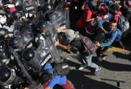 Migrants charge on Mexican National Guards at the border crossing between Guatemala and Mexico, near Ciudad Hidalgo, Mexico and Tecun Uman, Guatemala, Saturday, Jan. 18, 2020. More than a thousand Central American migrants surged onto a bridge spanning the Suchiate River that marks the border between both countries as Mexican security forces attempted to impede their journey north. (AP Photo/Marco Ugarte)