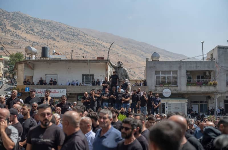 People mourn at the funeral of their relatives in the Druze town of Majd al-Shams in the Israeli-controlled Golan Heights. Several children and young people were killed in a rocket attack on a football field in the village. Ilia Yefimovich/dpa