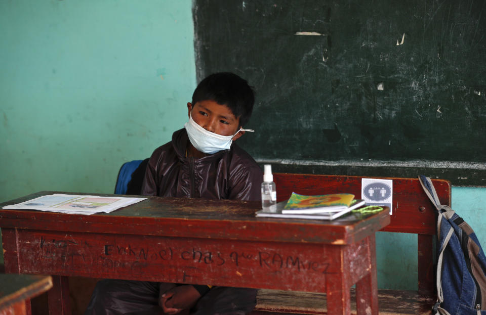 An Aymaran Indigenous student wears a mask and a new, protective uniform during the first week back to in-person classes amid the COVID-19 pandemic, near Jesus de Machaca, Bolivia, Thursday, Feb. 4, 2021. (AP Photo/Juan Karita)