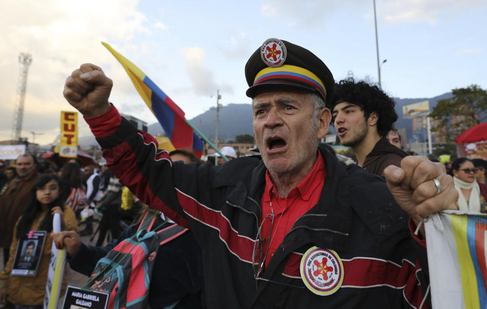 Anti-government protesters rally outside the National Center for Historical Memory, calling for the resignation of its director, Dario Acevedo, on Human Rights Day in Bogota, Colombia, Tuesday, Dec. 10, 2019. As soon as Acevedo was appointed to lead the center, victim organizations called for Colombian President Ivan Duque to reconsider, due to Acevedo's view that the conflict was less a formal struggle against rebels with a cause, than an effort to stamp out criminal and terrorist bands. (AP Photo/Fernando Vergara)