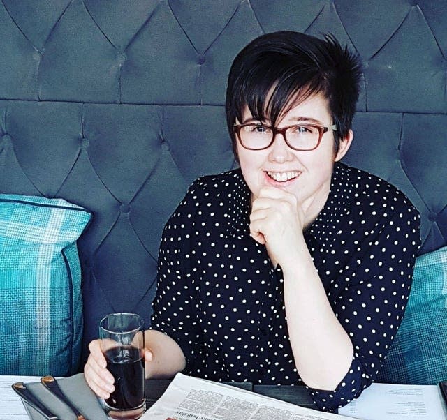 Journalist Lyra McKee sat at a table holding a glass