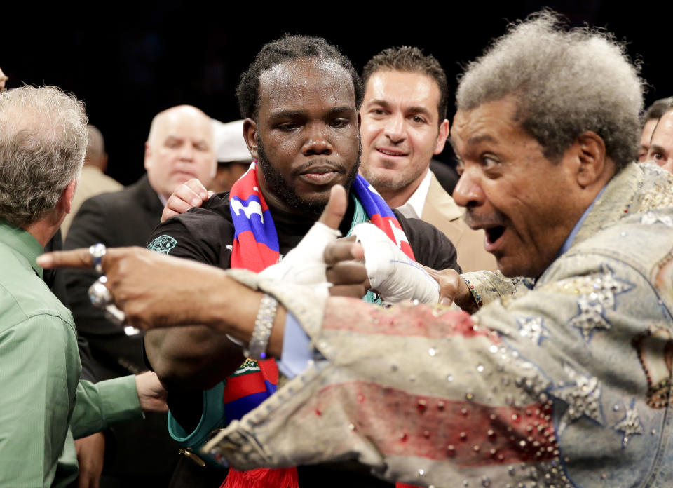 Bermane Stiverne, center, celebrates his win over Chris Arreola with promoter Don King after a rematch for the WBC heavyweight boxing title in Los Angeles, Saturday, May 10, 2014. (AP Photo/Chris Carlson)