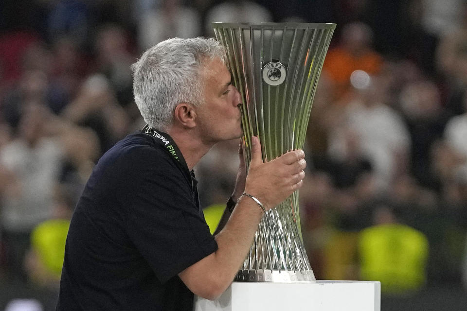 FILE - Roma's head coach Jose Mourinho, right, kisses the trophy after winning the Europa Conference League final soccer match between AS Roma and Feyenoord at National Arena in Tirana, Albania, Wednesday, May 25, 2022. Roma has announced on Tuesday, Jan. 16, 2024 that José Mourinho is leaving the club “with immediate effect.” The Portuguese coach led the Giallorossi to the UEFA Conference League title in his first season. (AP Photo/Thanassis Stavrakis, File)