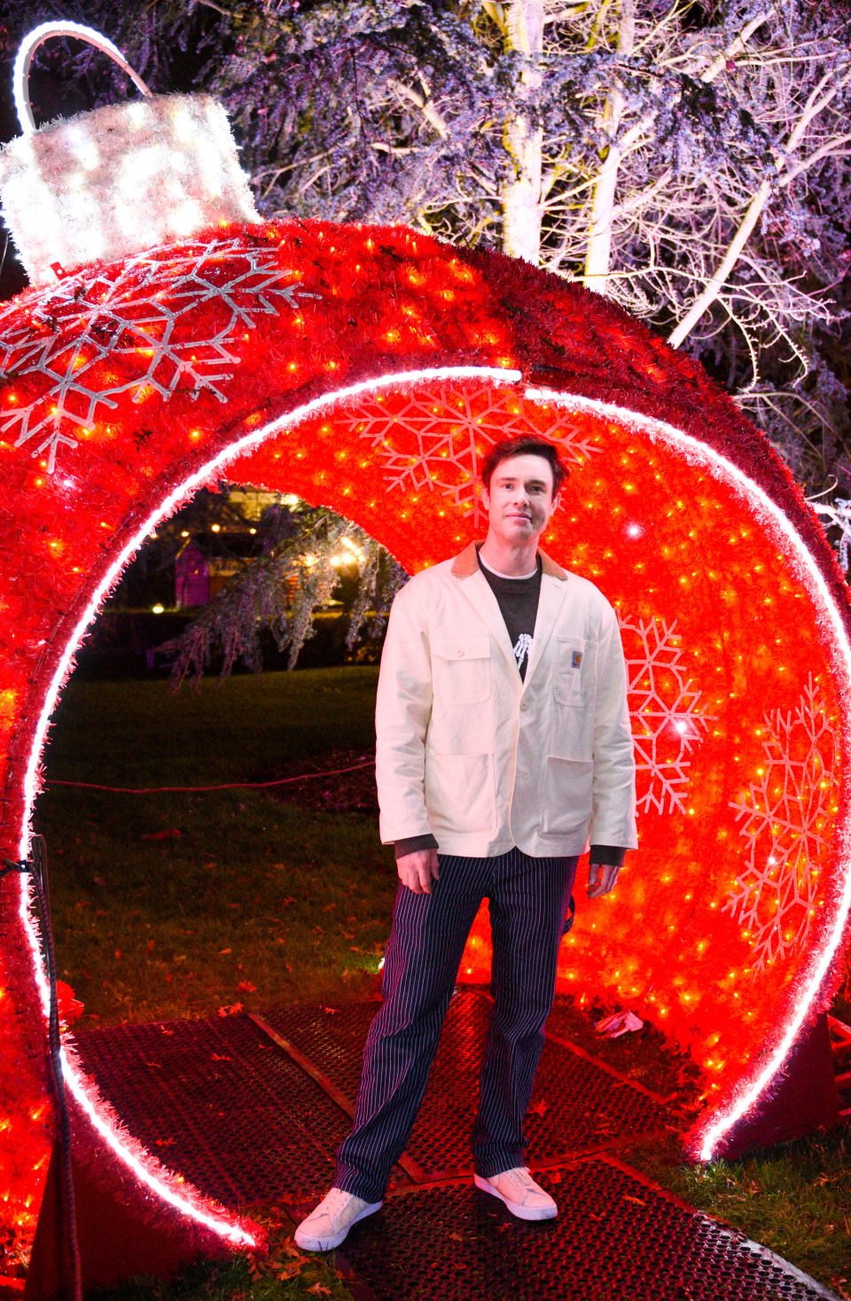 Ed Gamble stands in a giant bauble decoration as he attends a VIP Preview of 