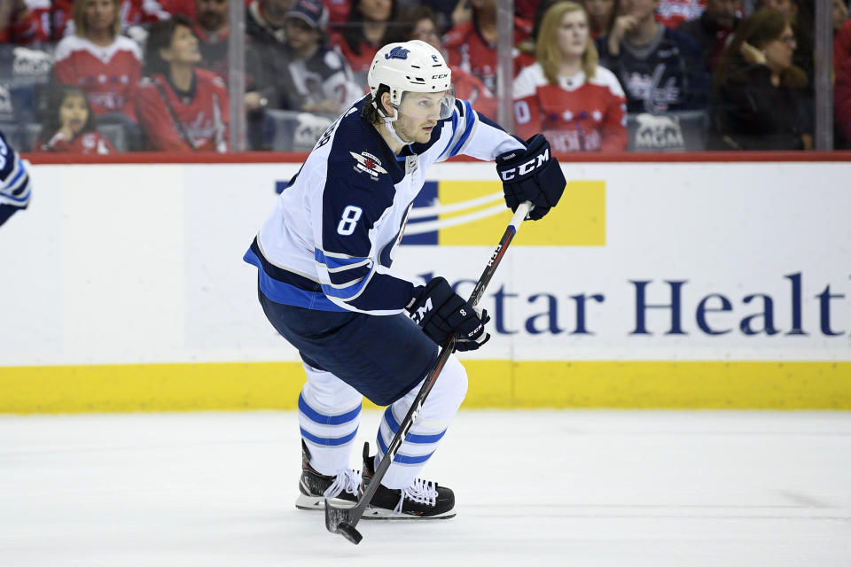 FILE - In this March 10, 2019, file photo, Winnipeg Jets defenseman Jacob Trouba (8) skates with the puck during the first period of an NHL hockey game against the Washington Capitals in Washington. After the offseason additions of star winger Artemi Panarin and defenseman Jacob Trouba, goaltender Henrik Lundqvist says the New York Rangers have to set their own realistic expectations for themselves this season. That process is one of several things to watch around the NHL when training camps open Thursday. (AP Photo/Nick Wass, File)