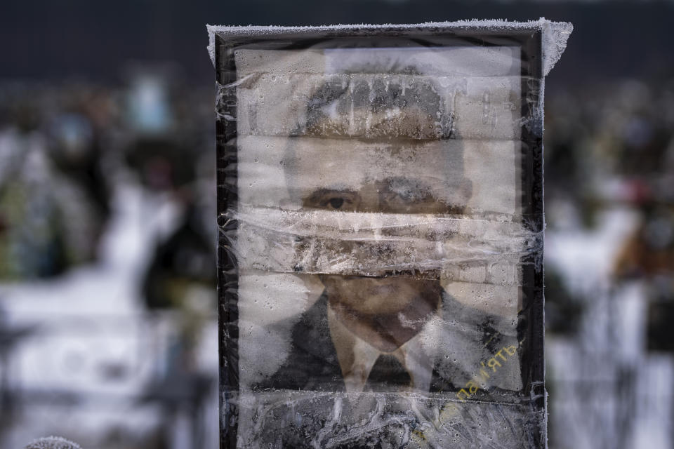 A worn-out portrait of Samar Volodymyr Mykolayovych, 64, sits on his grave at a cemetery in Irpin, Ukraine, on the outskirts of Kyiv, on Thursday, Feb. 9, 2023. He was buried on March 5, 2022. (AP Photo/Emilio Morenatti)