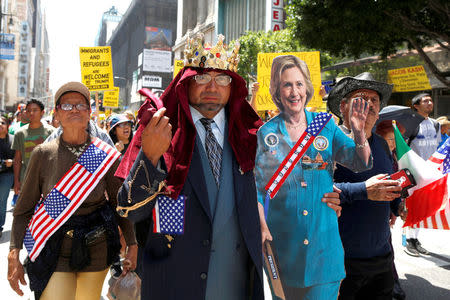 A man marches with a cardboard cutout of Democratic presidential candidate Hillary Clinton during an immigrant rights May Day rally in Los Angeles, California, U.S., May 1, 2016. REUTERS/Lucy Nicholson