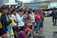 Residents and relatives wait for news of their loved ones a day after a ferry transporting nearly 200 people capsized, at the pier in the central Philippine city of Ormoc, on July 3, 2015