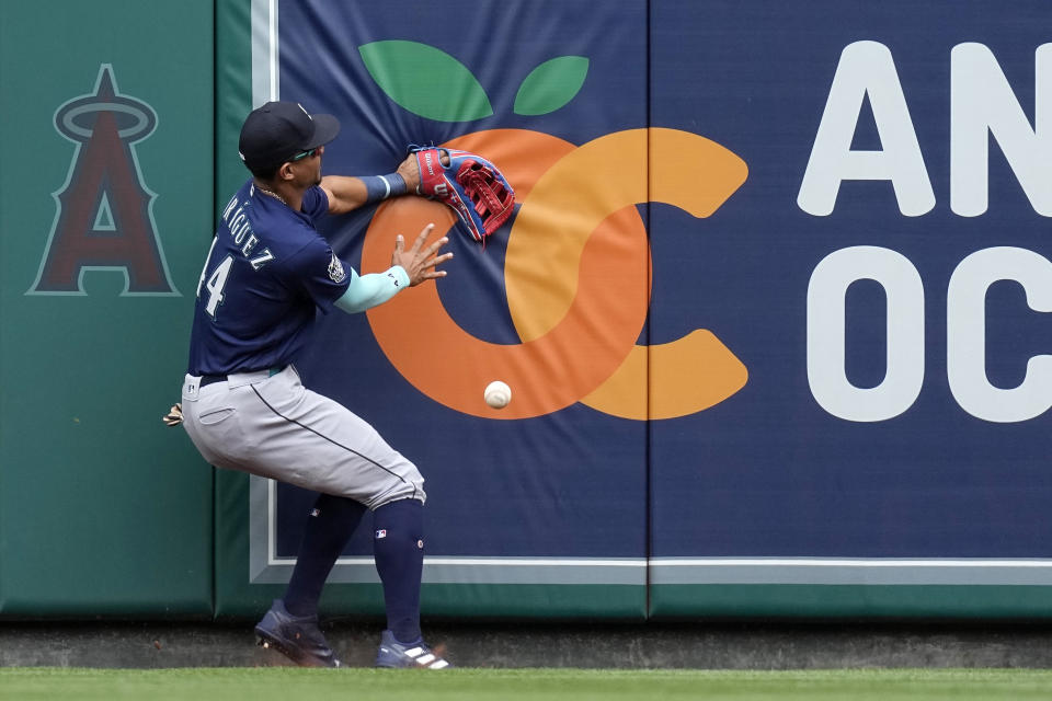 Seattle Mariners center fielder Julio Rodriguez hits the wall as he is unable to get to a ball hit for a double by Los Angeles Angels' Brandon Drury during the first inning of a baseball game Sunday, June 11, 2023, in Anaheim, Calif. (AP Photo/Mark J. Terrill)
