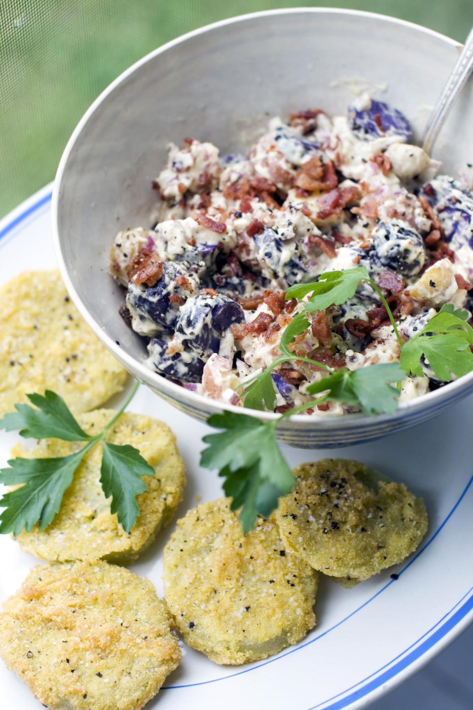 In this image taken on June 10, 2013, panko-crusted fried green tomatoes, bacon mayonnaise and fingerling potato salad are shown served on a plate in Concord, N.H. (AP Photo/Matthew Mead)