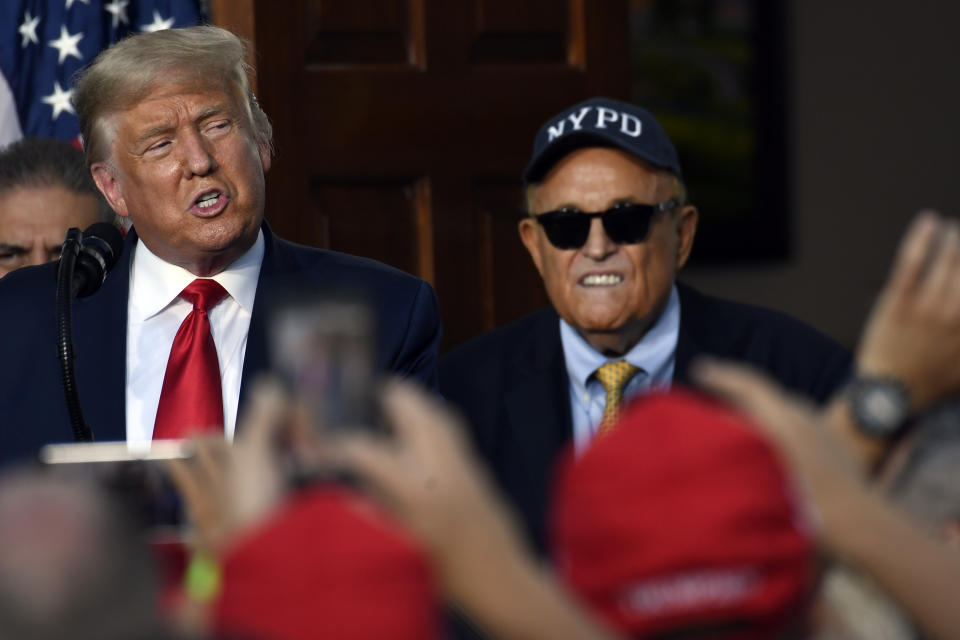 President Donald Trump speaks as Rudy Giuliani, an attorney for President Donald Trump watches, during an event Trump National Golf Club, Friday, Aug. 14, 2020, in Bedminster, N.J., with members of the City of New York Police Department Benevolent Association. (AP Photo/Susan Walsh)