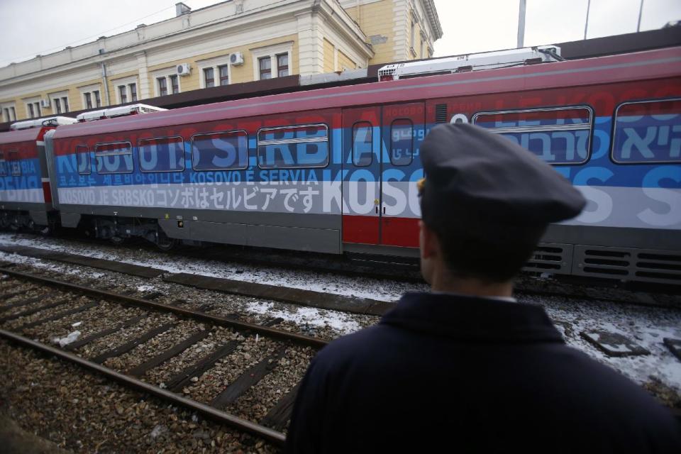 A railroad worker stands by the first train decorated with letters that read "Kosovo is Serbian" written in twenty languages departing from the Belgrade to Mitrovica, Kosovo at Belgrade's railway station, Serbia, Saturday, Jan. 14, 2017. Serbia has launched a railway link to Serb-dominated northern Kosovo despite protests from authorities in Pristina who described the move as a provocation and an aggressive violation of Kosovo's sovereignty. (AP Photo/Darko Vojinovic)