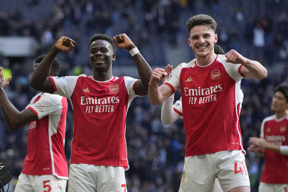 Arsenal's Bukayo Saka and Declan Rice celebrate at the end of the English Premier League soccer match between Tottenham Hotspur and Arsenal at the Tottenham Hotspur Stadium in London, England, Sunday, April 28, 2024. (AP Photo/Kin Cheung)